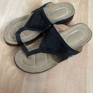 Black dress sandal with pink rosette design embroidered on the side